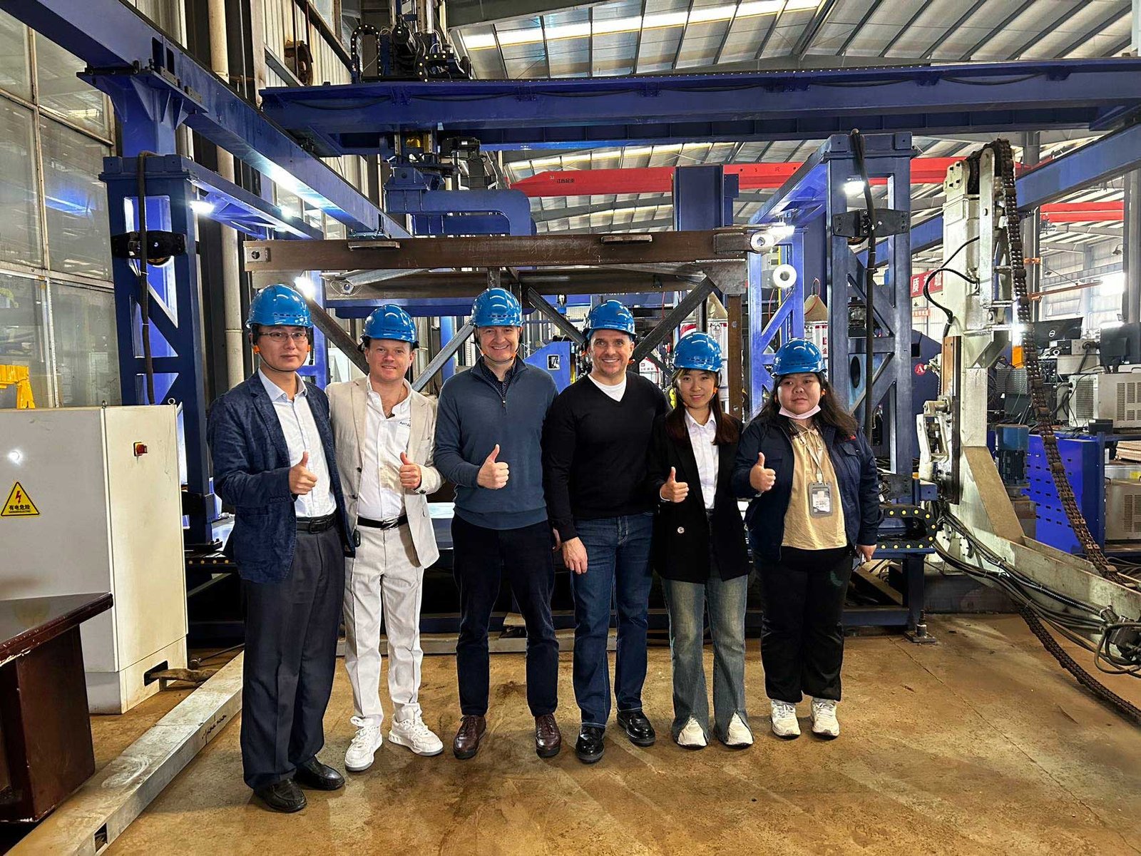 Group of engineers and business partners in a tower crane manufacturing facility