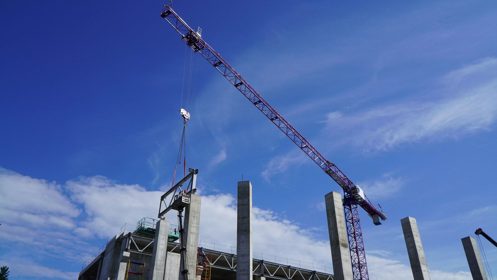 Tower crane lifting construction materials at an industrial site