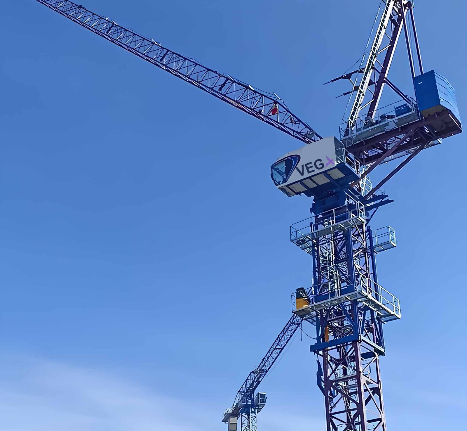 VEGA tower crane at construction site, clear blue sky in the background